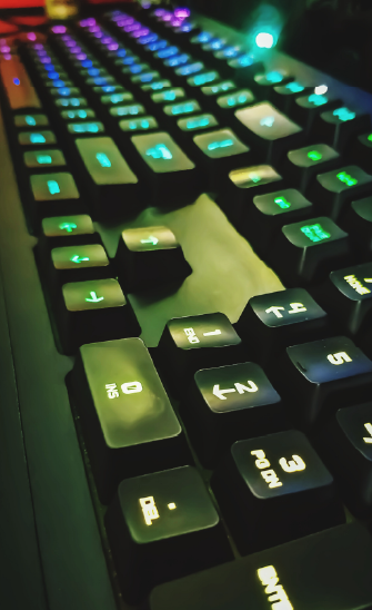 Un clavier d'ordinateur en gros plan avec des touchex rétroéclairées de plusieurs couleurs.
