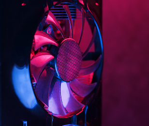 Gros plan sur un ventilateur d'ordinateur éclairé par une lumière tamisée violette